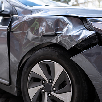 Damaged front fender on dark silver car